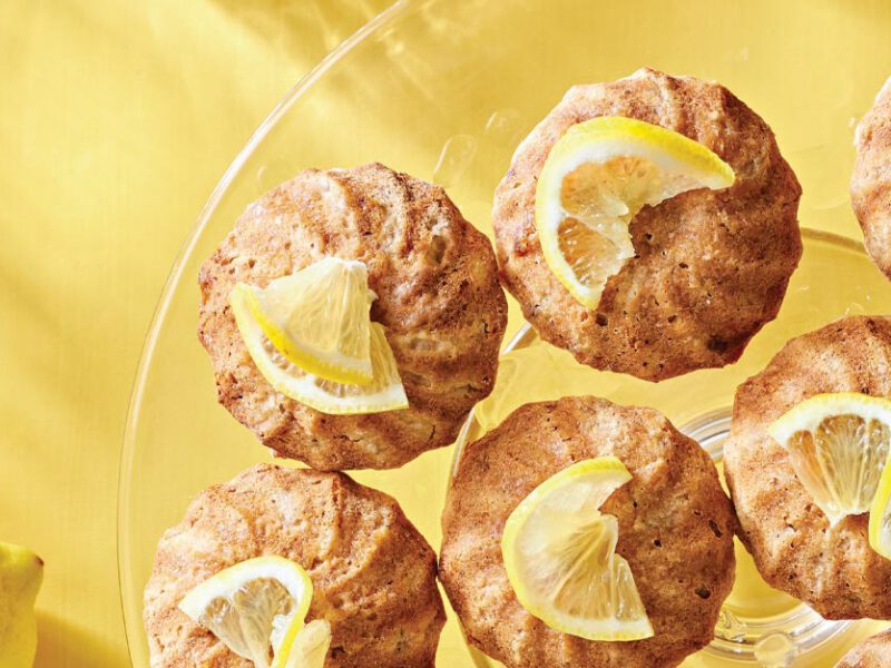 Lemon-Glazed Oatmeal Snack Cakes on a glass plate against a bright yellow background