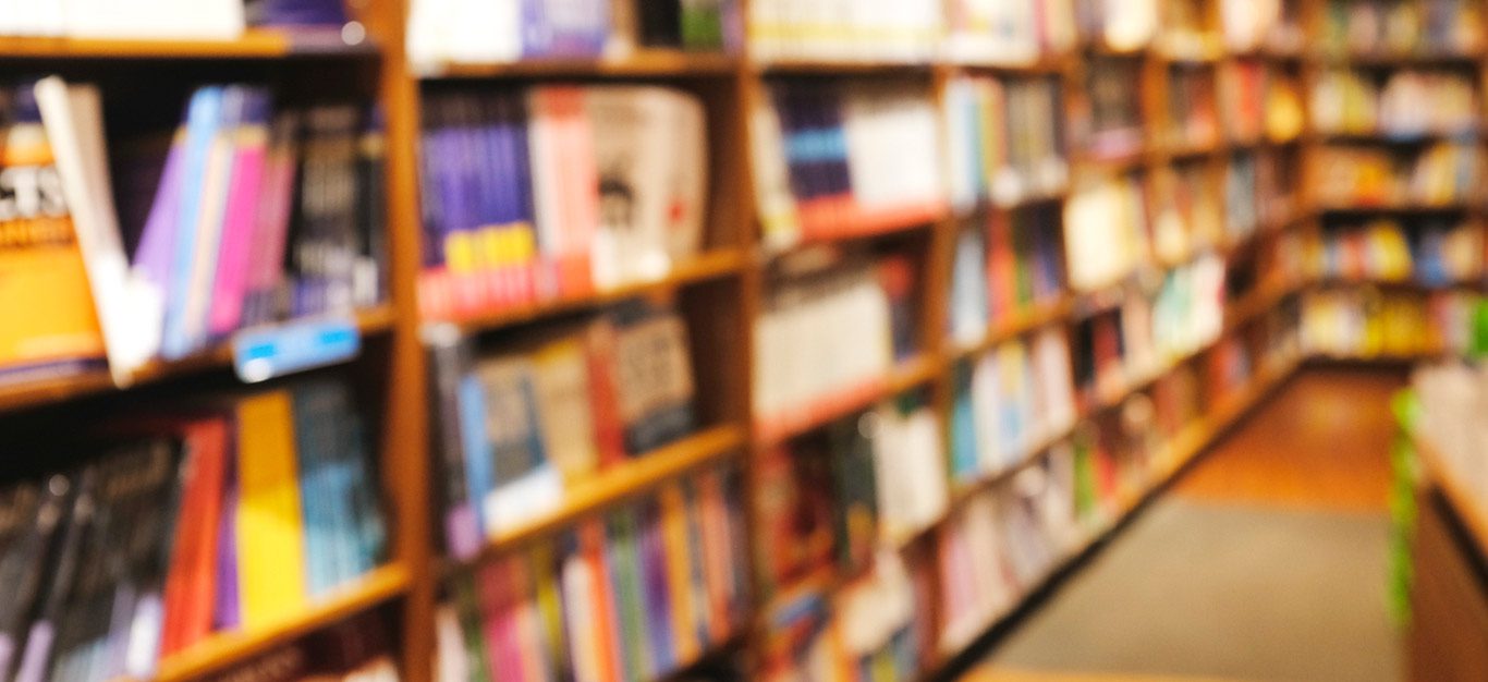 A blurred image of books on the shelves of a bookstore