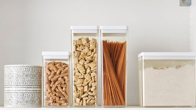 Items in a healthy plant-based pantry, including dried whole wheat pasta and whole wheat flour in clear containers