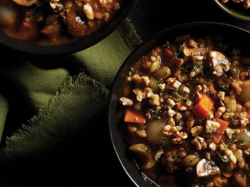 Instant Pot Mushroom-Barley Stew in black bowls with green cloth napkins