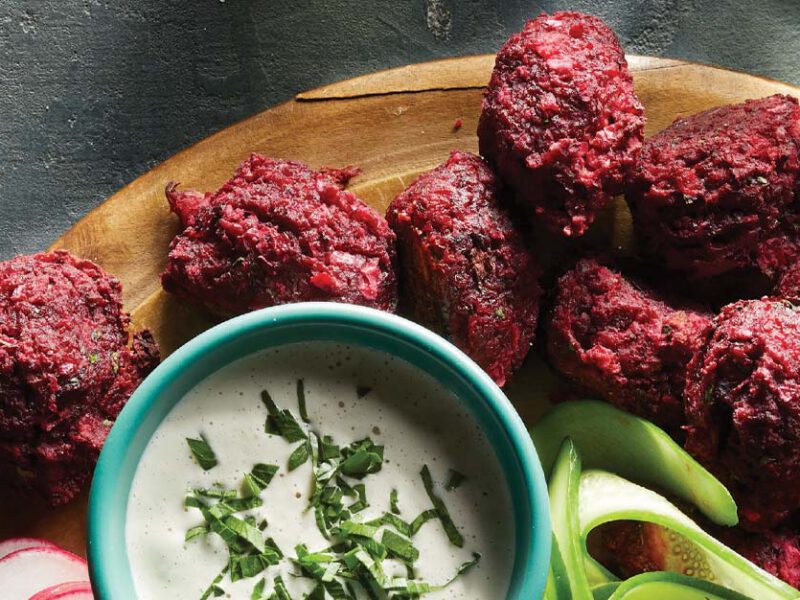 Roasted Beet Falafel with Chile-Lime Tahini Sauce on a round wooden platter