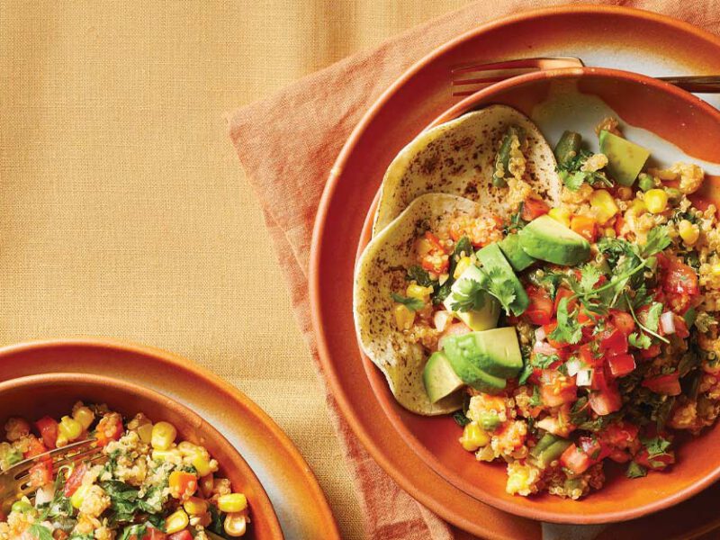 Quinoa Taco Bowls in orange ceramic bowls against a light orange fabric tablecloth