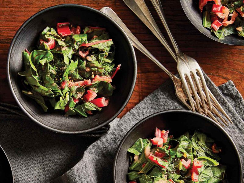 Ethiopian Collard Greens and Chard in gray bowls against a dark wood tabletop