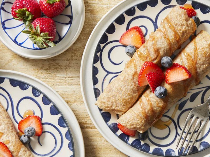 Vegan Palacinky (Czech Sweet Crepes) on blue and white china plates topped with fresh berries