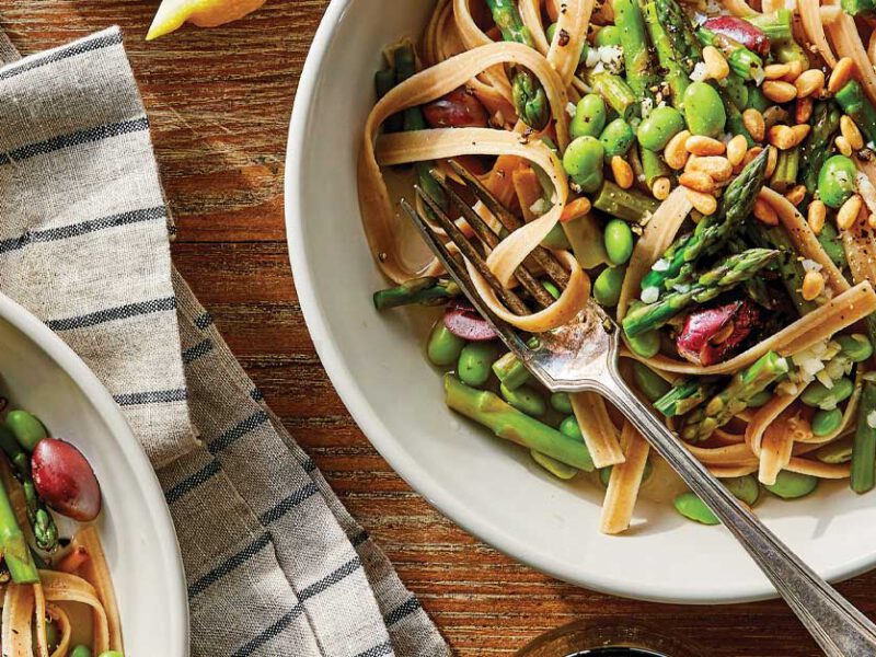 Lemony Asparagus Fettuccine in white bowls with metal forks against a wood tabletop