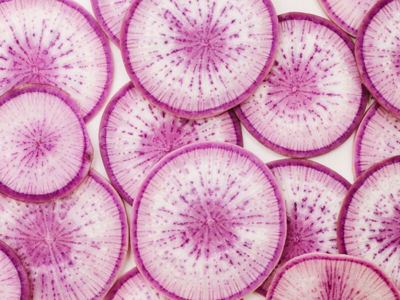 A close up view of thinly sliced radish slices overlapping