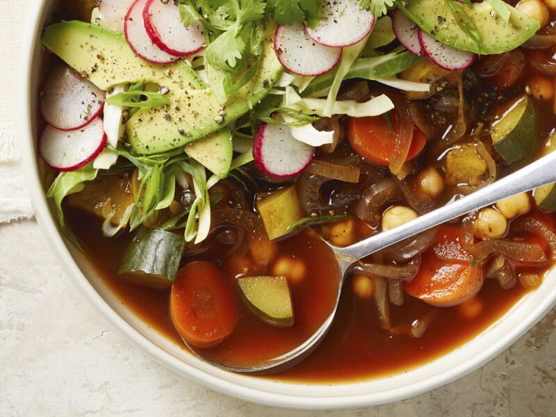 30-Minute Chickpea Pozole in a white bowl with a metal spoon