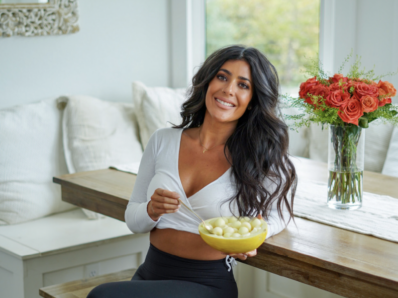 Cookbook author Kiki Nelson of plantifully lean sits in her home eating balled melon