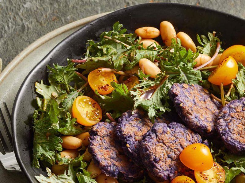 Purple Potato Croquettes with Kale Salad in a gray ceramic bowl