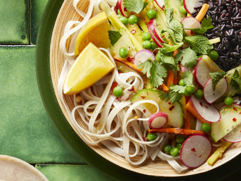 Refreshing Vietnamese Noodle Salad in a white bowl on a green tile background