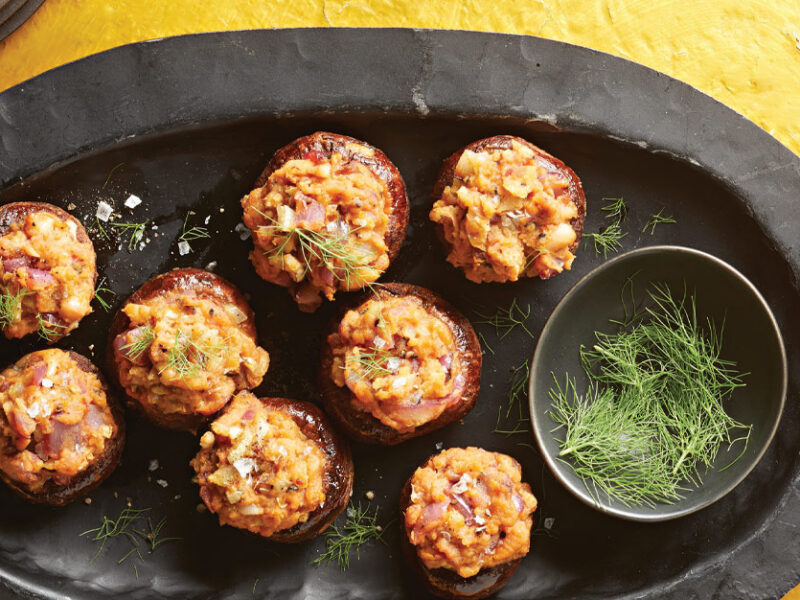 Smoky Vegan Stuffed Mushrooms on a slate serving tray against a yellow background