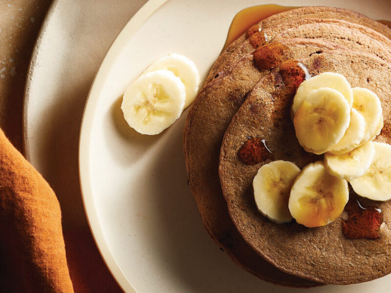 Chocolaty Black Bean Pancakes with sliced bananas on a cream colored plate