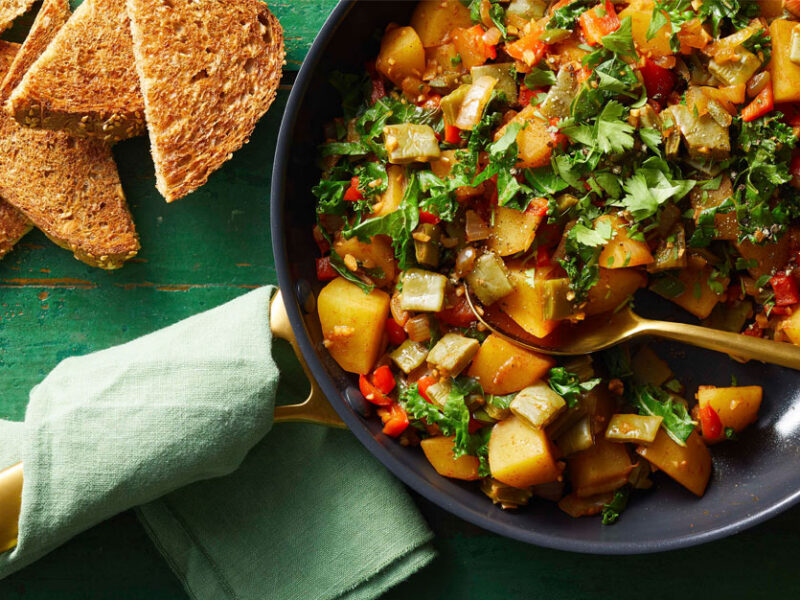Nopales and Potatoes Breakfast Hash in a grey bowl against a green wooden tabletop