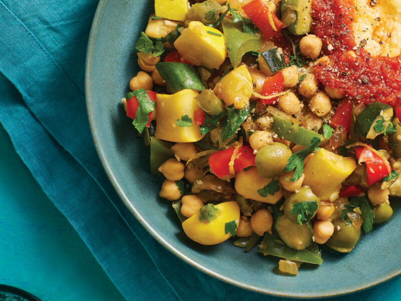 Mediterranean Pepper and Squash Hash with Creamy Polenta in a blue ceramic bowl against a teal background
