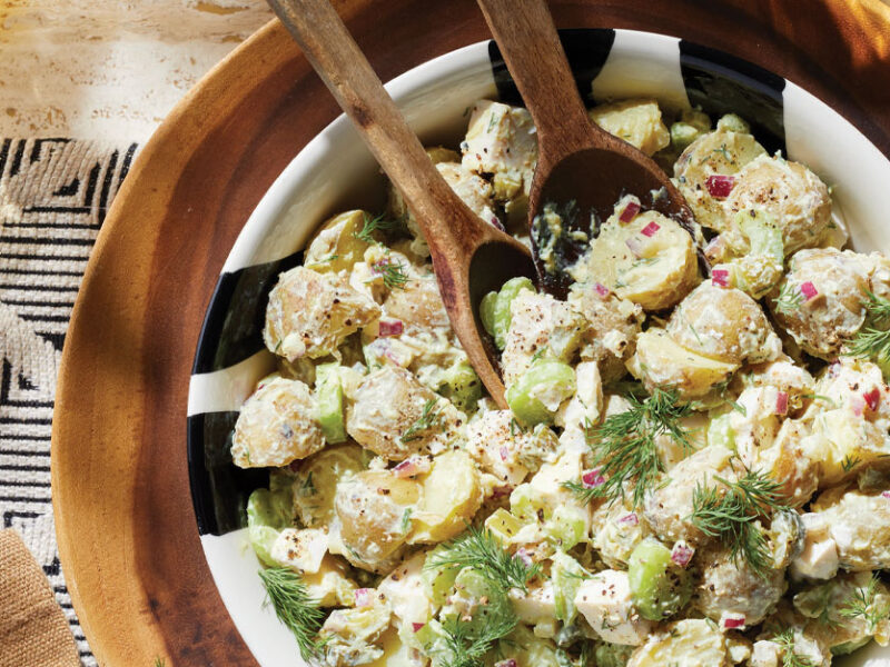 Old-Fashioned Potato Salad with Vegan Mayo in a wooden bowl with wooden serving spoons