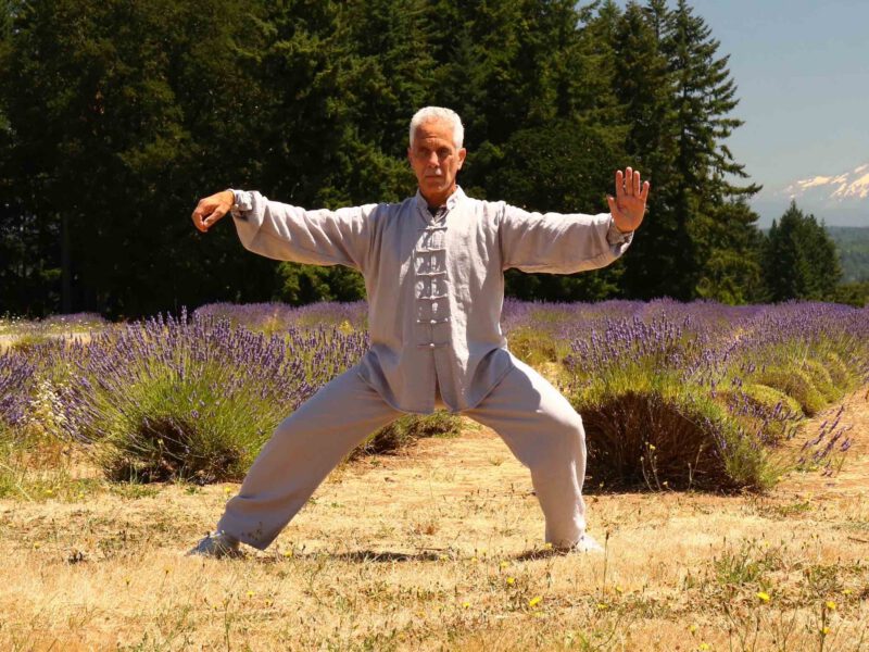 A senior man (Dr. Robert Bacher) practices taiji in a lavender field