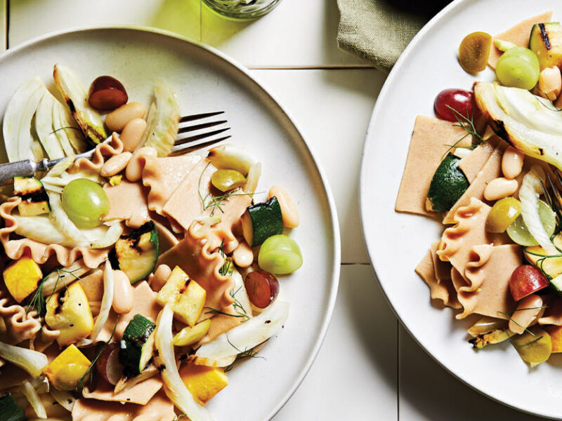 Grilled Summer Squash Pasta Salad on white plates with metal forks on top of white tile