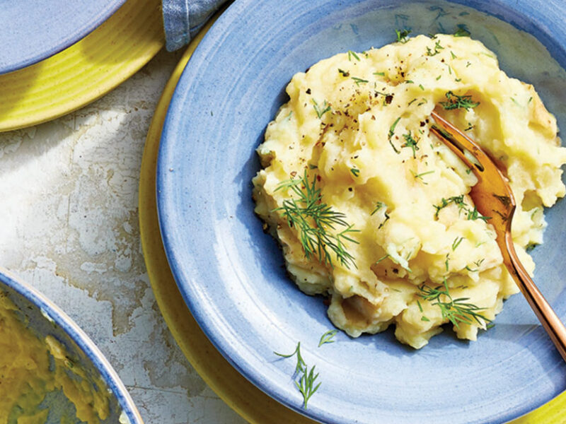 Lemon and Dill Mashed Potatoes in a blue bowl with a gold metal fork
