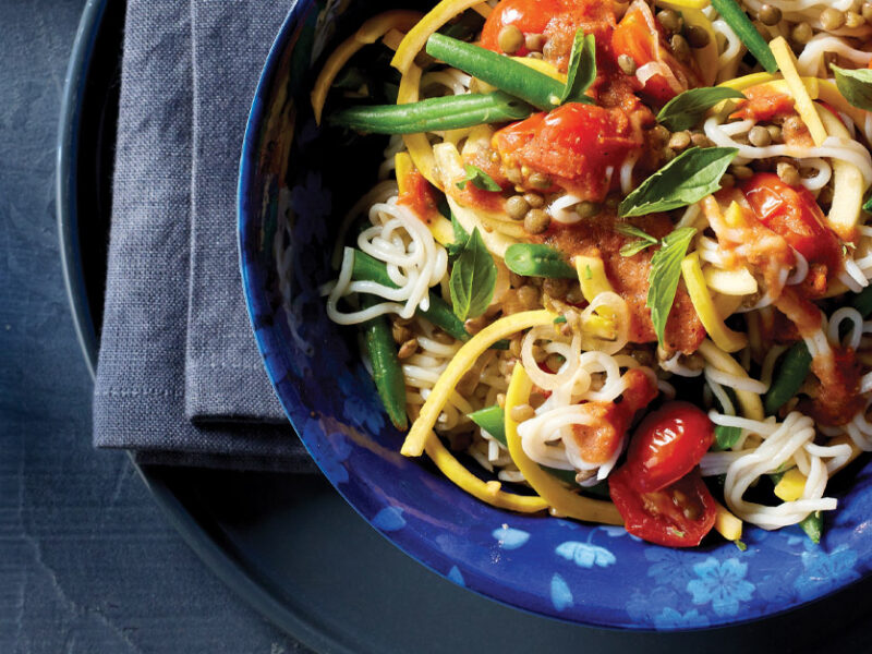 Tofu Shirataki Noodles with Lentils, Green Beans, and Tomatoes in a dark blue bowl