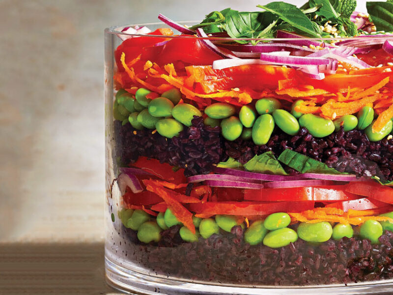 Layered Black Rice Salad in a large glass serving bowl