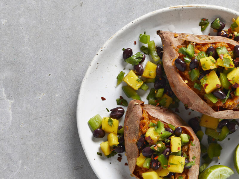 Caribbean Loaded Sweet Potatoes on a white plate against gray countertop