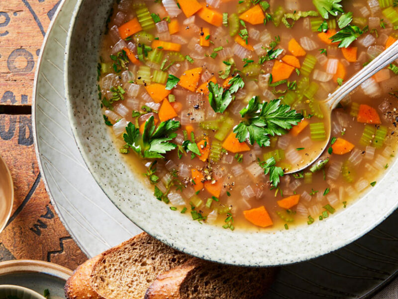 Chestnut soup in a white bowl with a metal spoon and side of dark bread