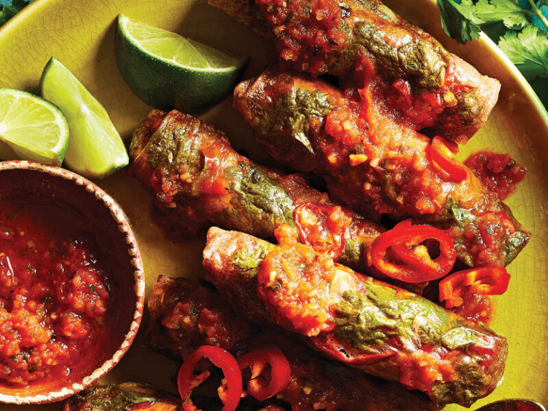 Air-Fried Southwest Spring Rolls on a yellow plate with lime wedges and a small bowl of salsa