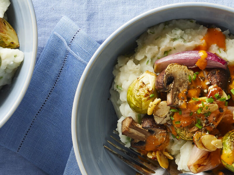 Roasted Veggie Bowls with Garlic Mashed Potatoes and vegan queso sauce in light blue ceramic bowls against a light blue linen tablecloth