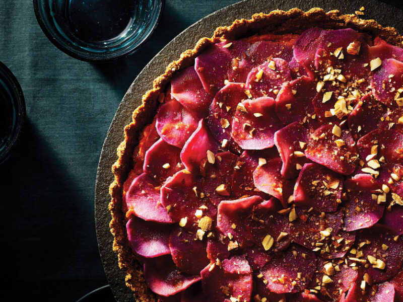 Sweet Potato Rosette Tart on a grey cake stand against a dark blue tablecloth