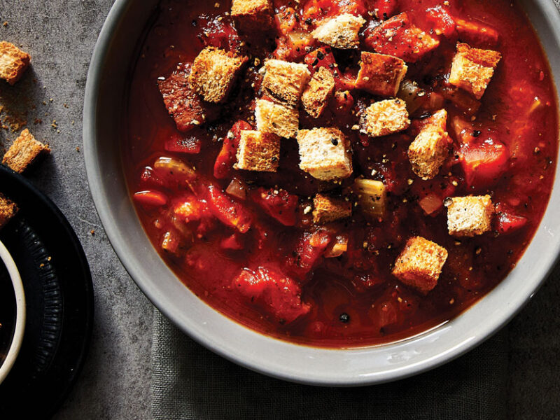 Spicy Tomato Soup with Whole Wheat Croutons in grey ceramic bowls against a slate countertop