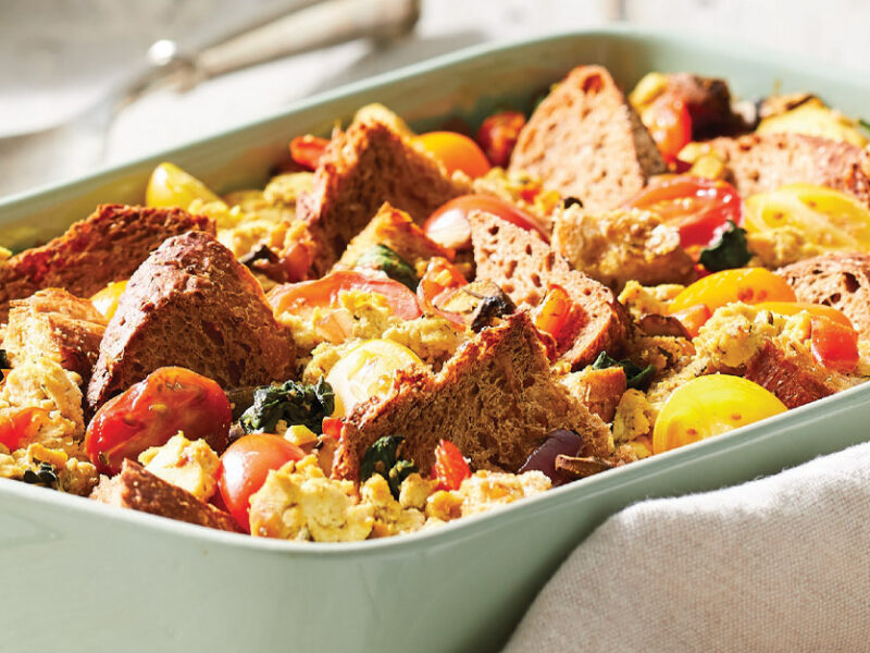 Scrambled Tofu Casserole with Mushrooms and Spinach in a light green ceramic casserole dish