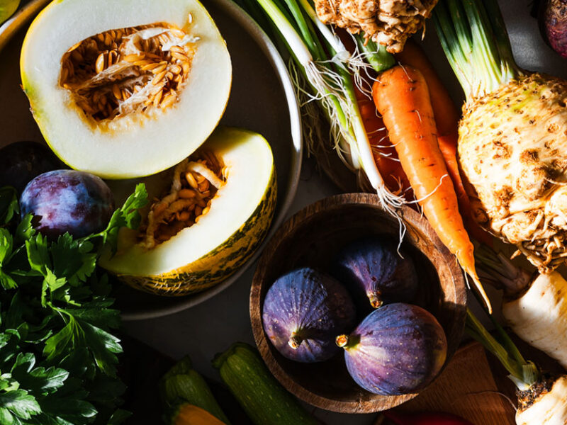 an abundant array of fall vegetables and fruits that are in season during autumn, including squash, carrots, parsnips, celeriac, figs, and leafy greens
