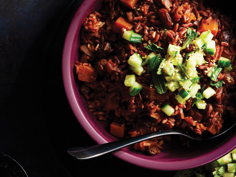 Middle Eastern Red Rice Pilaf in a purple ceramic bowl against a dark background