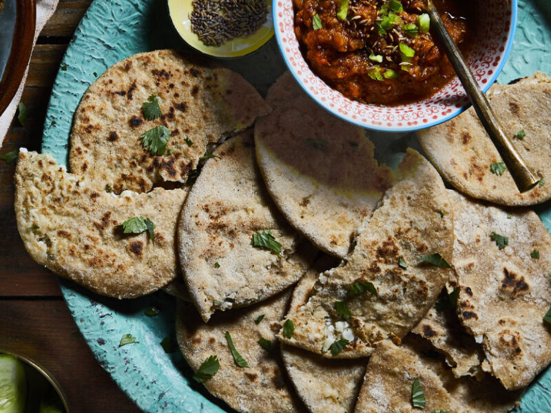 Cauliflower Parathas served on a turquoise plate with small bowl of tomato chutney