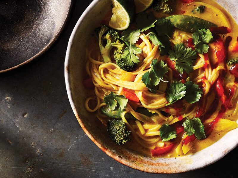 Khow Suey (Burmese Curry Noodle Soup) in a white ceramic bowl against dark gray background