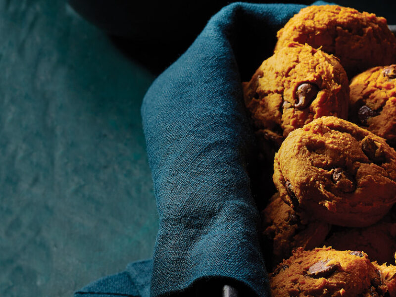 Sweet Potato Chocolate Chip Cookies resting in a dark blue cloth in a rectangular baking tin