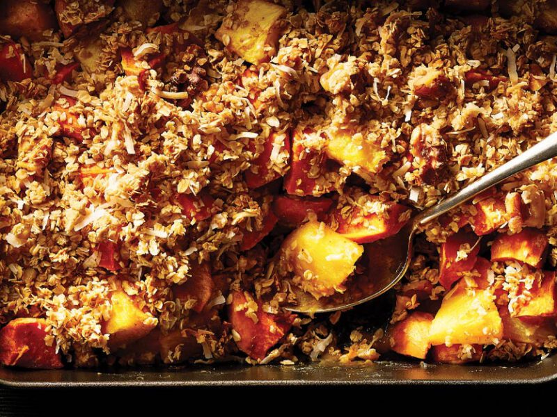 Sweet Potato and Pineapple Crisp in a rectangular cast iron dish against a dark green background