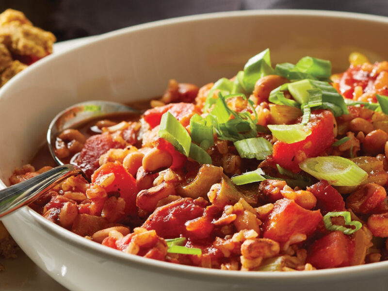Veggie Jambalaya with Black-Eyed Peas in a whitw ceramic bowl with a side of cornbread