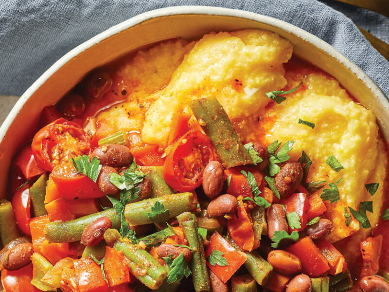 Spicy Cajun Hash on Grits in a white ceramic bowl on top of a blue cloth napkin