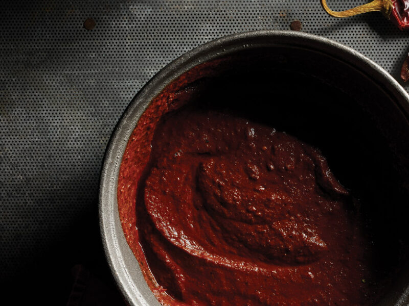 Easy Mole Sauce in a gray ceramic bowl against a dark gray background