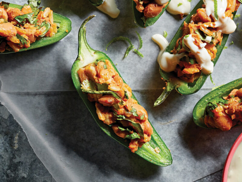 Vegan Stuffed Jalapeños with Lime Crema against a dark gray countertop