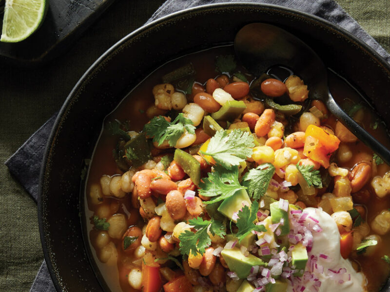 Pinto Bean and Hominy Soup in a black ceramic bowl