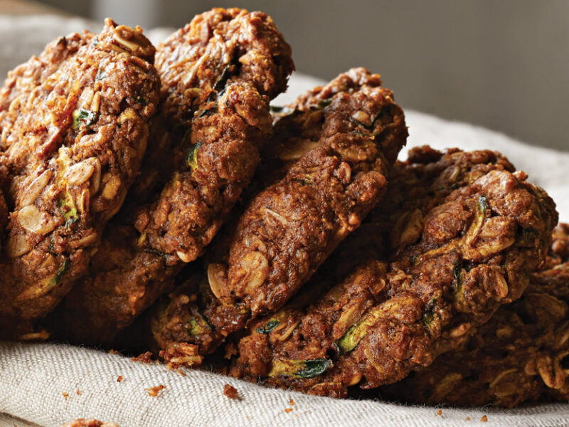 Dreamy Zucchini Breakfast Cookies stacked in a row on a white kitchen towel