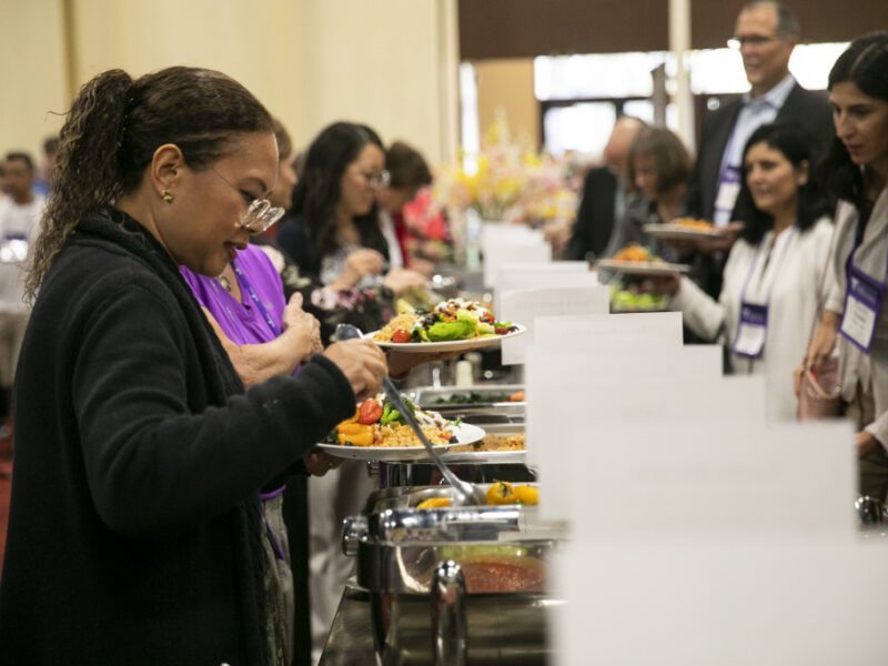 Attendees of the Plant-Based Nutrition Healthcare Conference serve themselves whole food plant based lunch at a buffet
