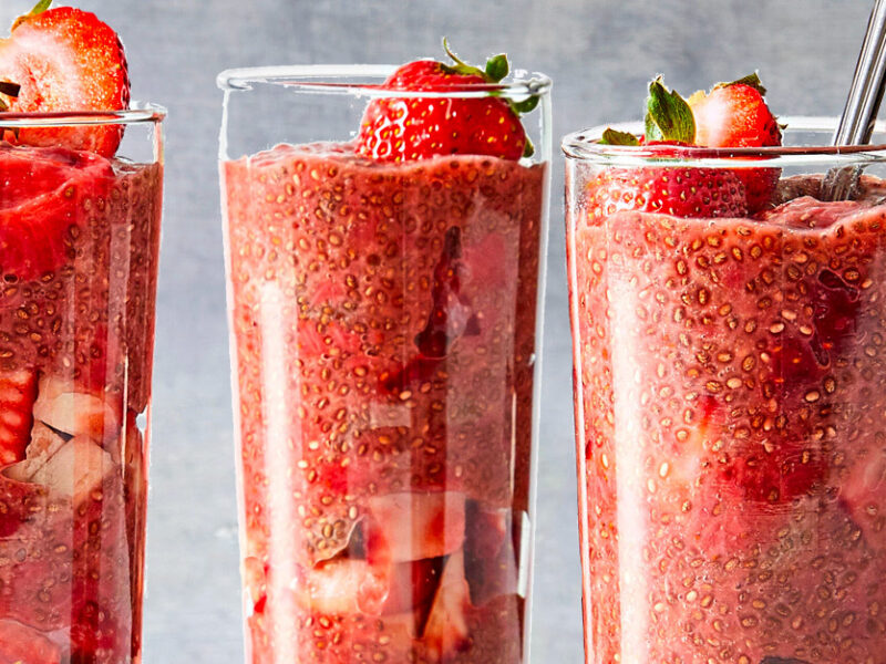 Strawberry Chia Seed Pudding in tall parfait glasses against a gray background