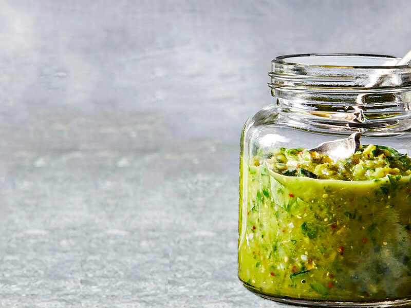 Spanish-Style Olive-Herb Sauce in a glass jar against a gray background