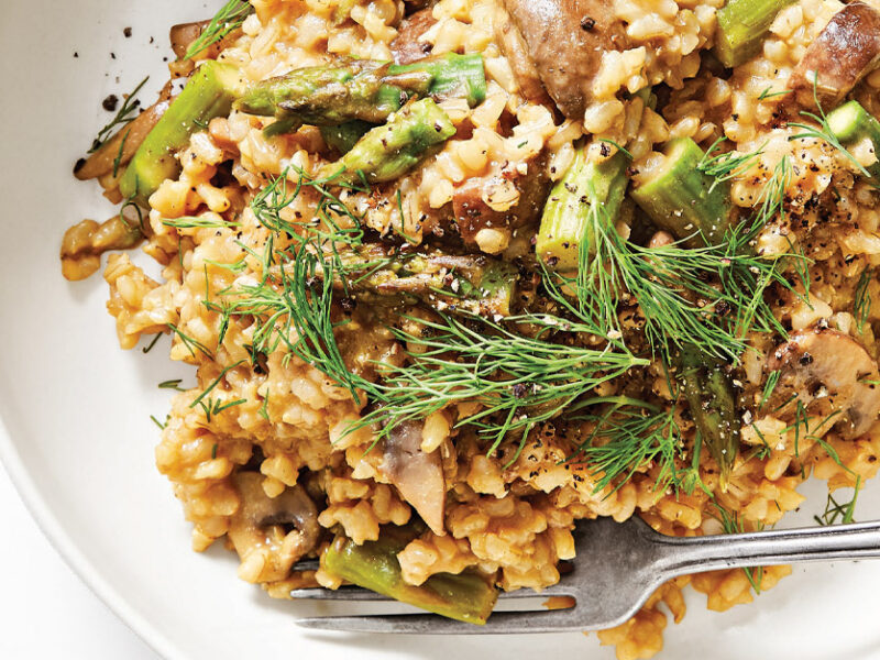 Wild Mushroom and Asparagus Risotto in a white ceramic bowl with a metal fork