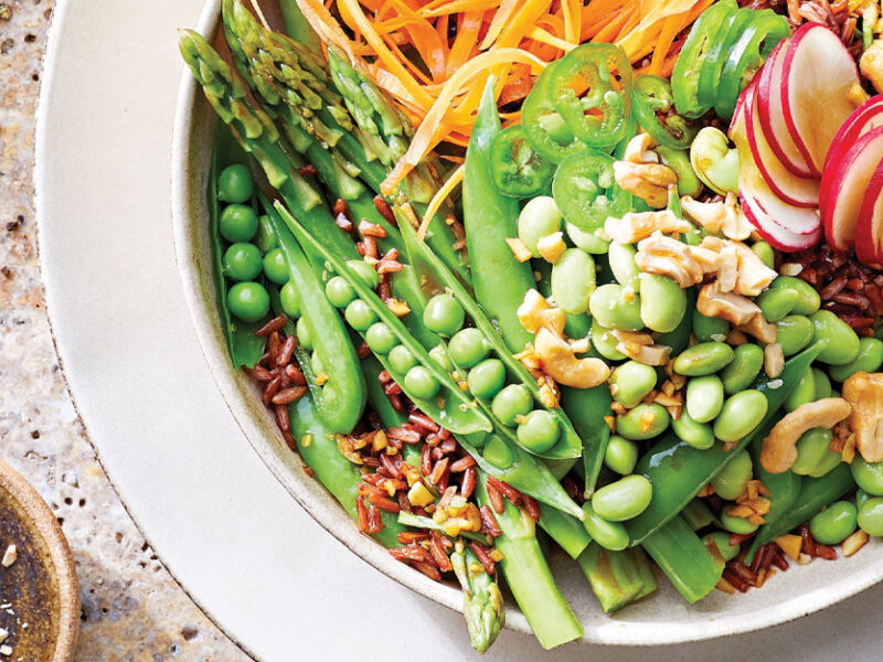Red Rice and Edamame Bowl with Spring Veggies in a white ceramic dish