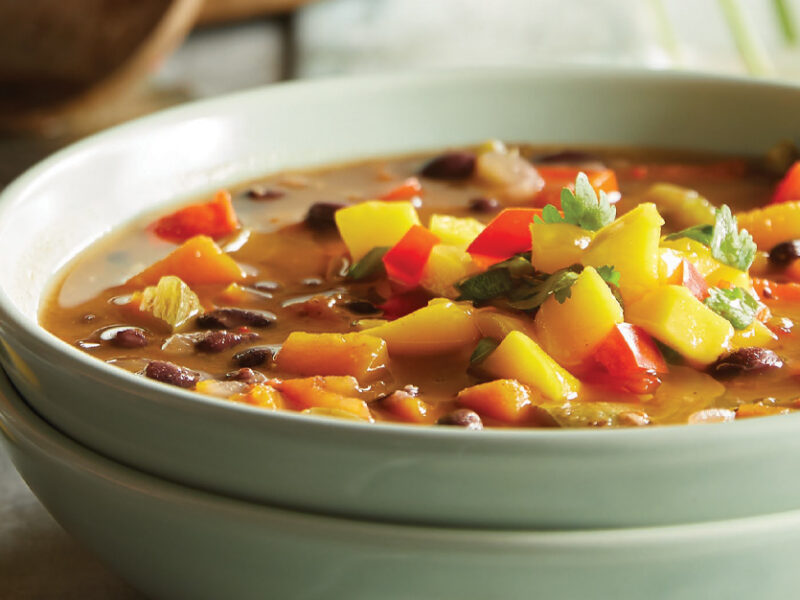 Jerk Black Bean Soup with Mango Salsa in a light green ceramic bowl