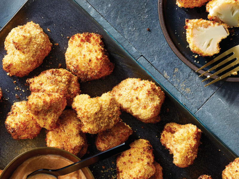 Air-Fried Cauliflower Poppers on a baking trap with a small bowl of Smoky Garlic Dipping Sauce